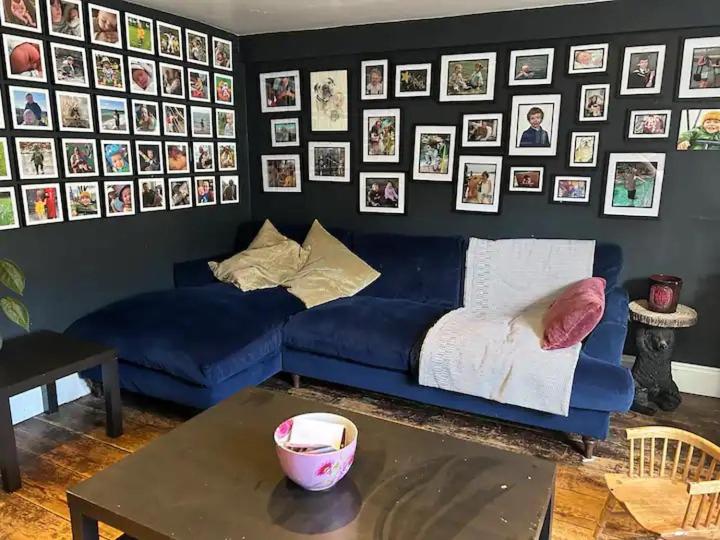 a living room with a blue couch and a table at 1 bed garden flat Islington in London