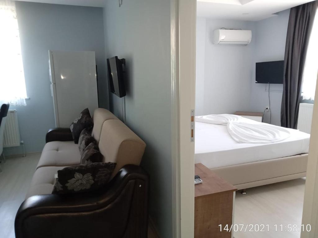 een woonkamer met een bank en een bed bij Hannapart Otel in Egirdir