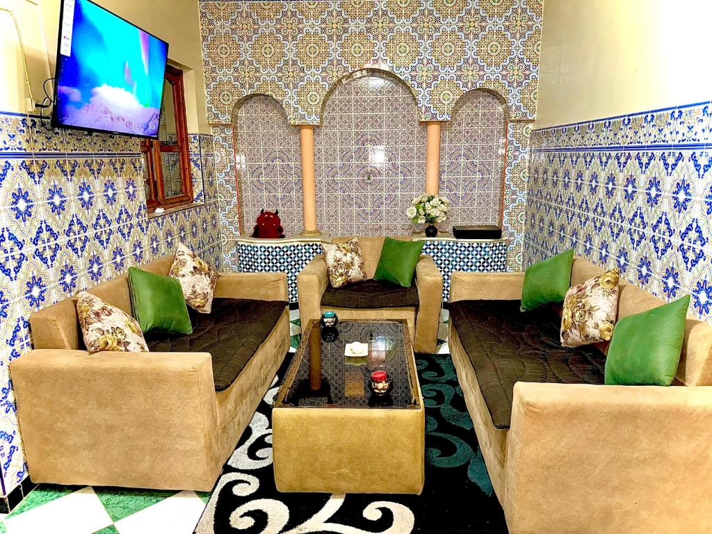 ein Wohnzimmer mit 2 Sofas und einem TV in der Unterkunft Mini villa in Oujda