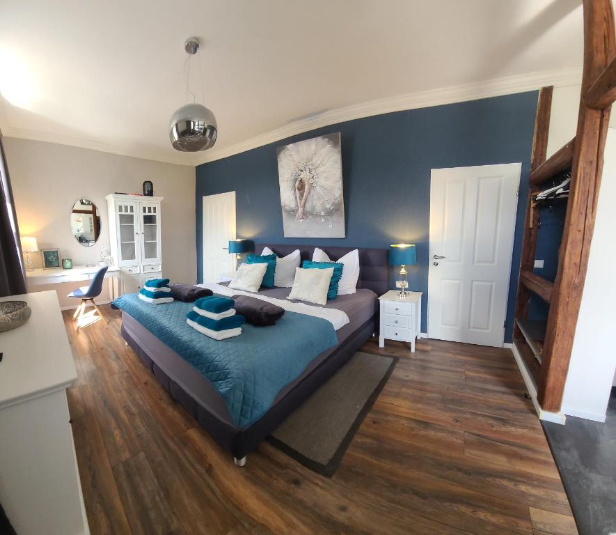 1 dormitorio con 1 cama grande y paredes azules en Luna et Sol - Haus Am See Seeblick-Apartment en Seehausen