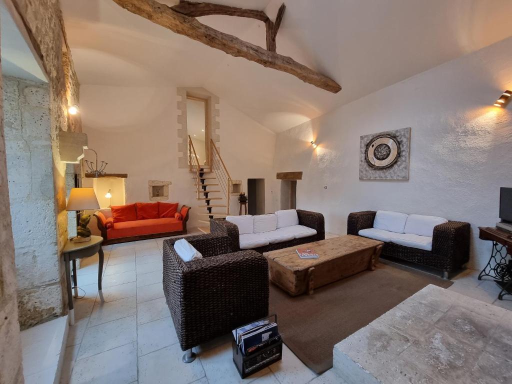 Un gîte en Charente, gîte 4 étoiles في Roullet-Saint-Estèphe: غرفة معيشة مع أرائك وأريكة حمراء