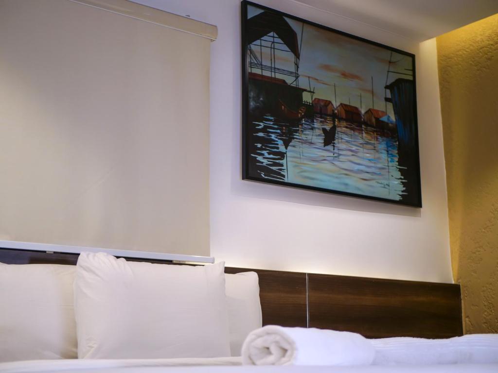 a hotel room with a bed with a painting on the wall at Oliver Twist Hotel in Lagos