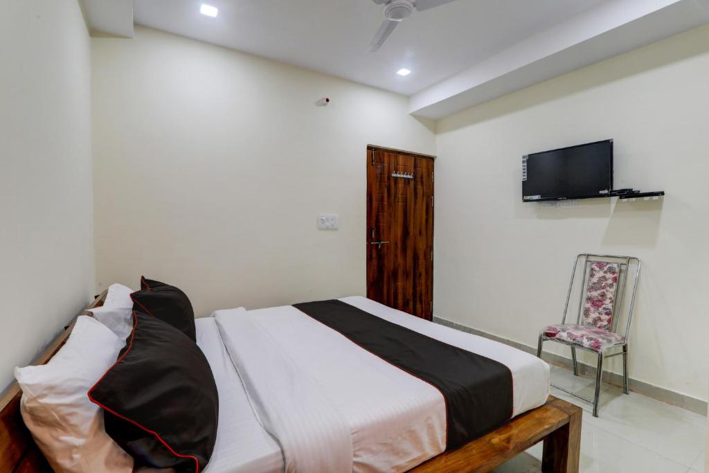 a bedroom with a bed and a tv and a chair at Flagship Skd Hotel And Banquet in Lucknow