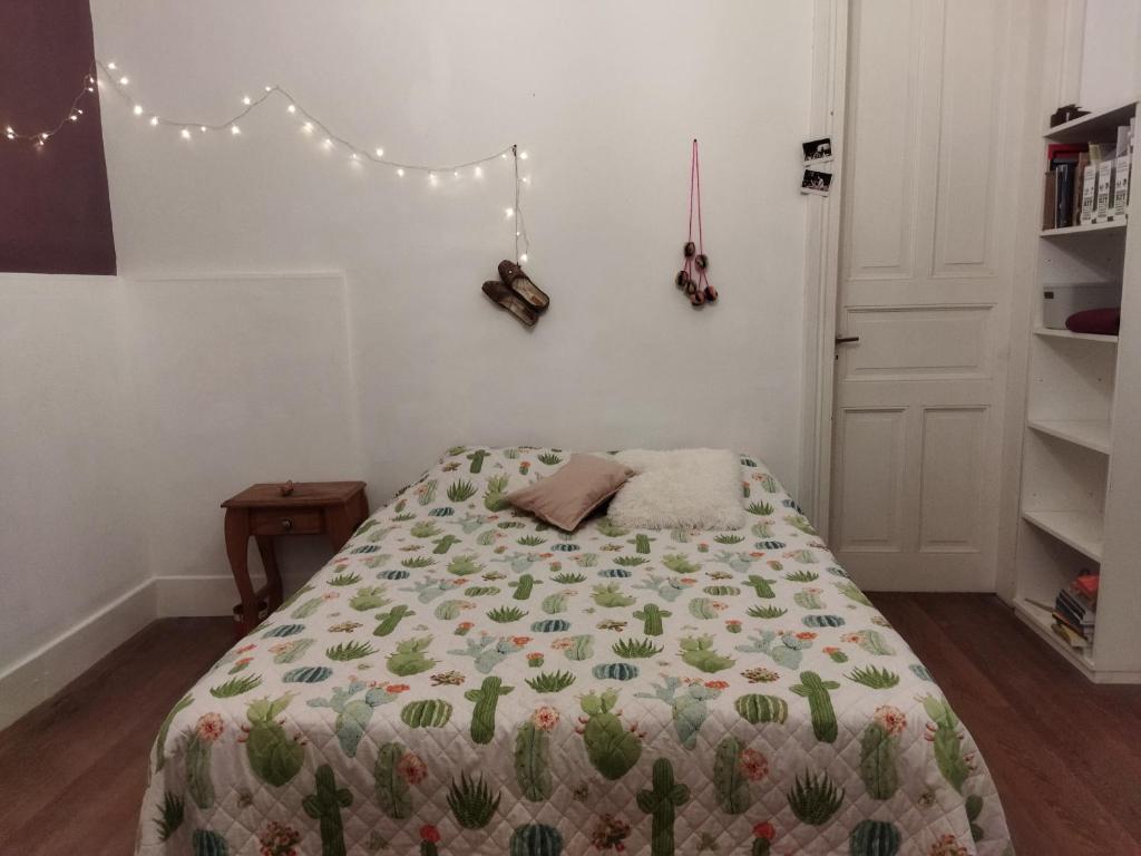 a bedroom with a bed with a cactus blanket at Casa Buda in La Plata