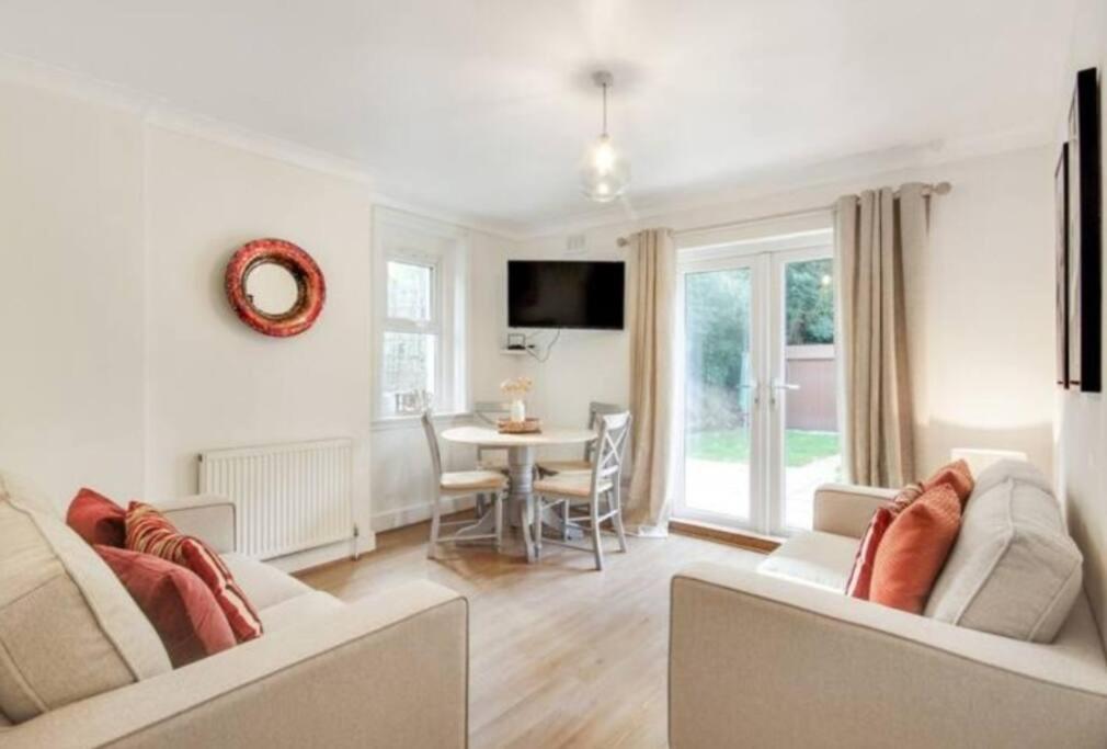 a living room with two couches and a table at Cosy 2 bedroom garden flat with parking in Royal Tunbridge Wells