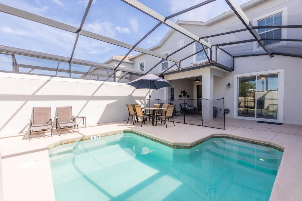 a house with a swimming pool and a table and chairs at MVP-4967WA SL townhouse in Kissimmee