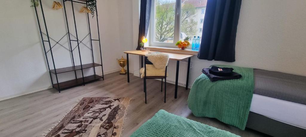 a room with a desk and a bed with a window at Dattel City Hannover FeWo für 4 Personen Privat-Parkplatz 5G WLAN & 24/7 Kontakt in Hannover