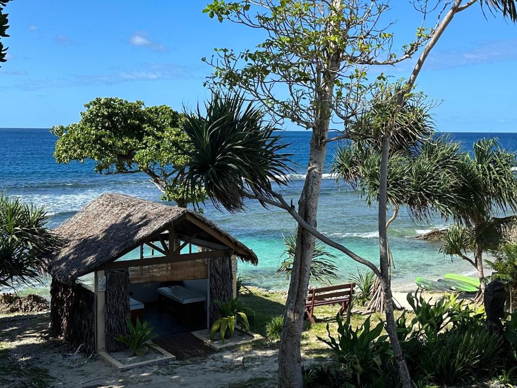 a small shack on the beach with the ocean at Nasama Resort in Port Vila