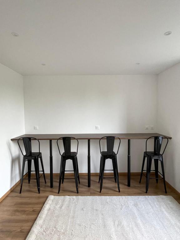 a table in a room with three black chairs at Colocation à côté d’Artem in Vandoeuvre-lès-Nancy