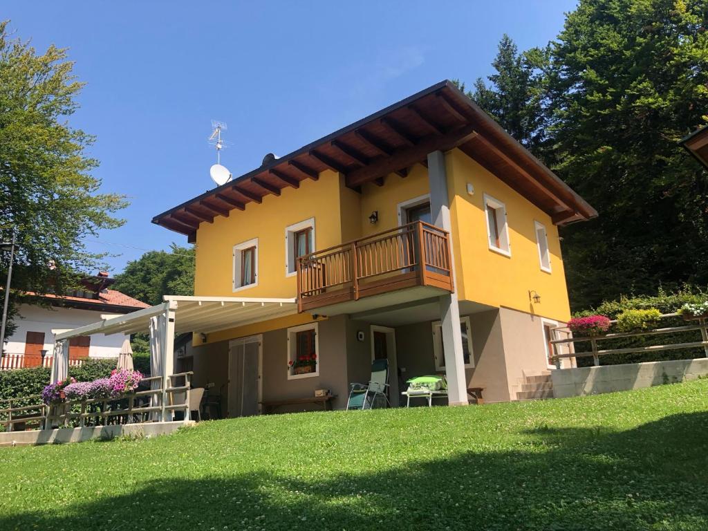 Casa amarilla con balcón y patio en Villa Botton d'Oro Villa al lago en Lagolo di Calavino