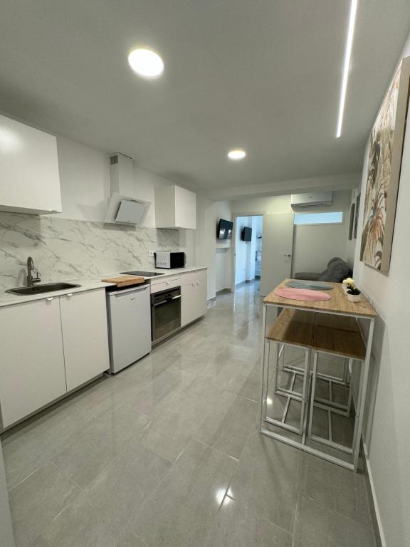 a large kitchen with white cabinets and a counter at Apartamento León céntrico, moderno y muy equipado in Almansa