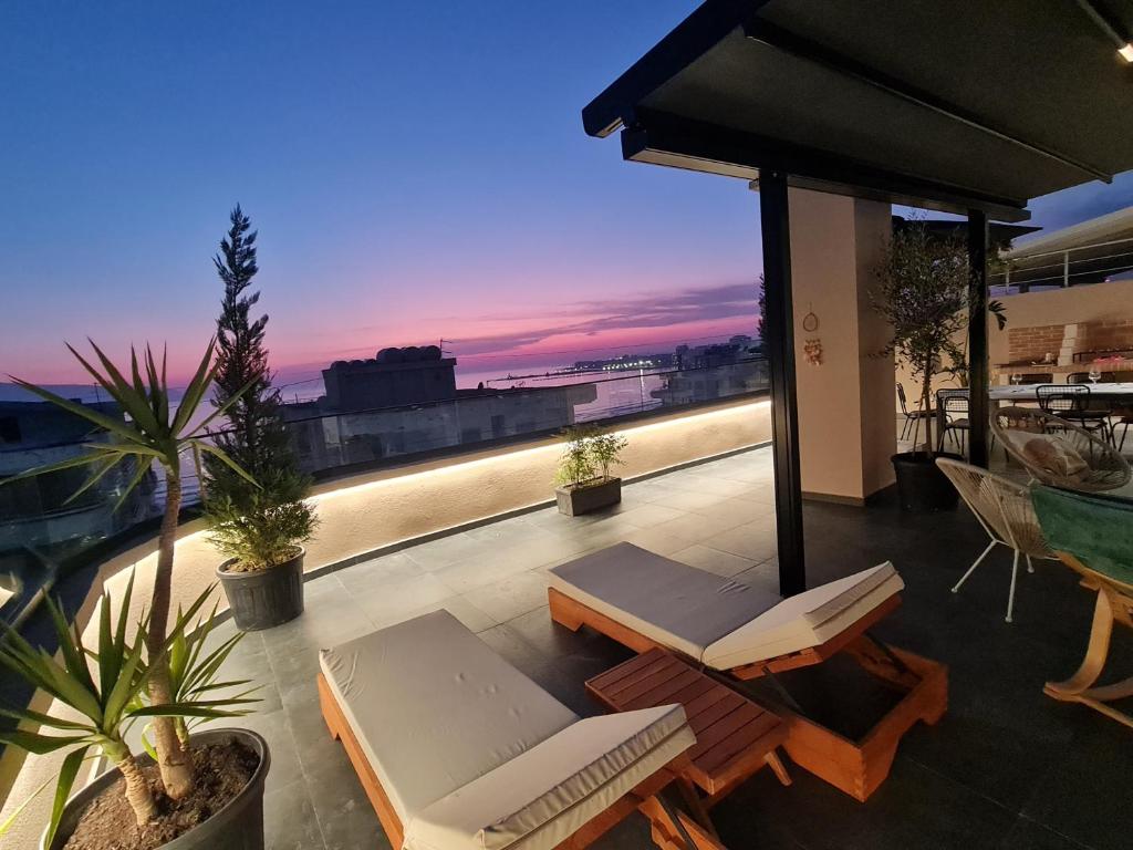 a balcony with chairs and a view of the city at SEA VIEW LUXURY PENTHOUSE in Vlorë