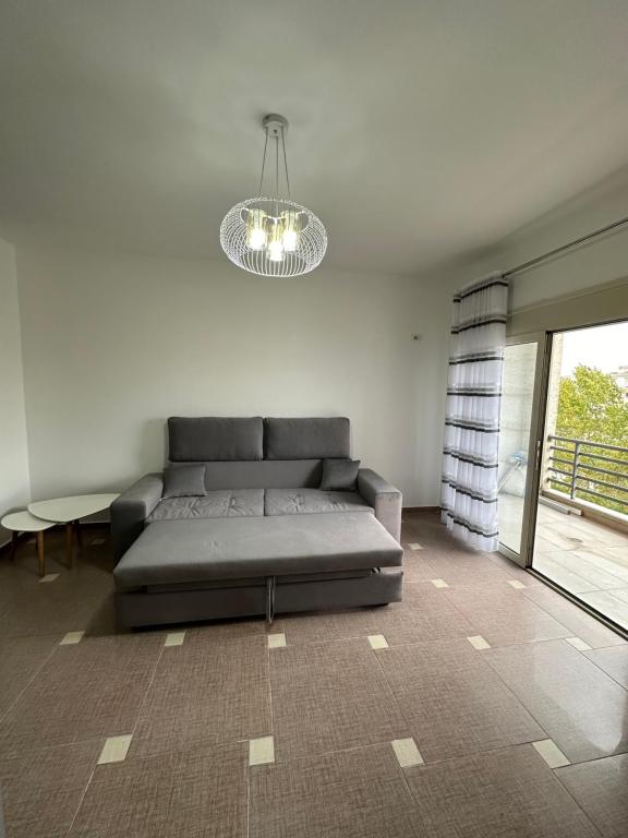 a living room with a couch and a chandelier at Cozy and Comfortable Apartment 2 in Durrës