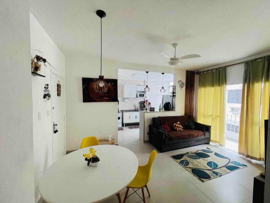 ein Wohnzimmer mit einem Tisch und einem Sofa in der Unterkunft Duplic Guaruja Enseada Apartamento in Guarujá