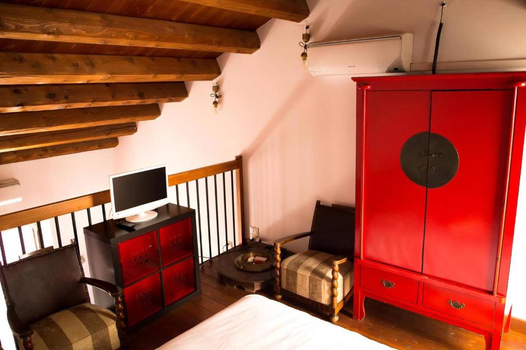 - un salon avec une armoire rouge et une télévision dans l'établissement Mau House 44 Apartment, à Palerme