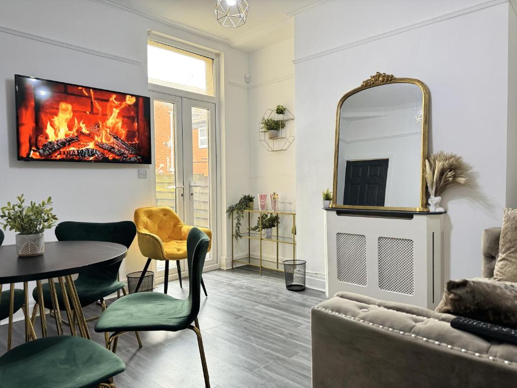 a living room with a fireplace and a table and chairs at 4 Bedroom Anfield House, 7 beds, Free Parking, Garden - 5 mins to LFC, 15 mins to City Centre in Liverpool