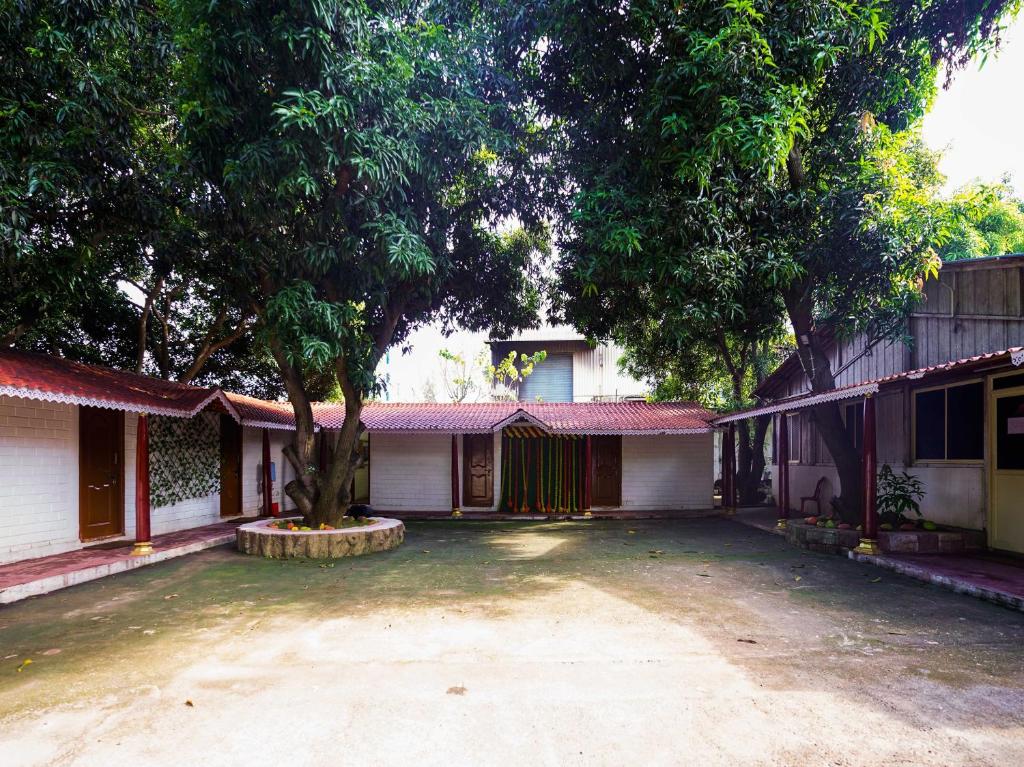 a house with a tree in the middle of a driveway at Manyura Hotels & Resorts in Vaiasavettikādu