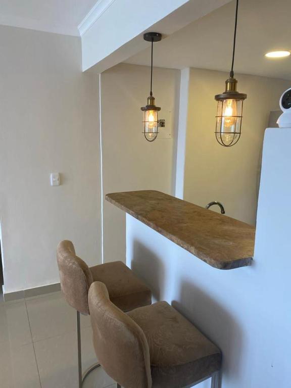 a kitchen with two chairs and a counter with two lights at Apartamento vista al mar in Cartagena de Indias
