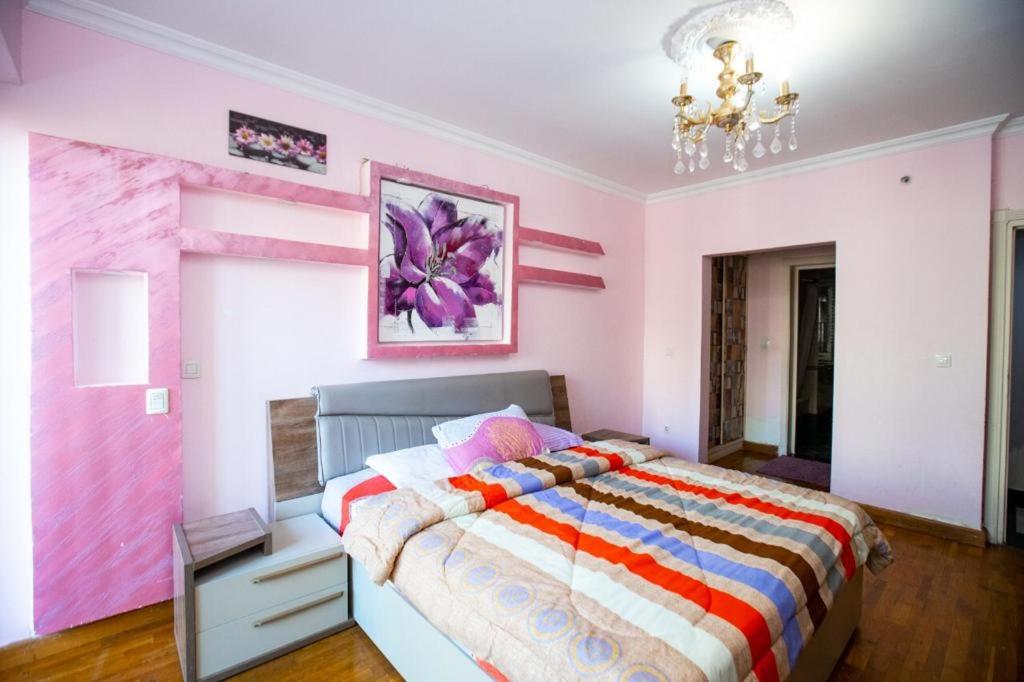 Four seasons Alexandria At San stefano apartment في الإسكندرية: غرفة نوم بسرير كبير بجدران وردية