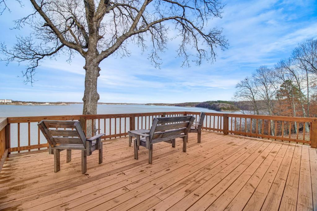 two benches sitting on a wooden deck with a tree at Grand Lake Views Pet-Friendly Jay Getaway! in Jay