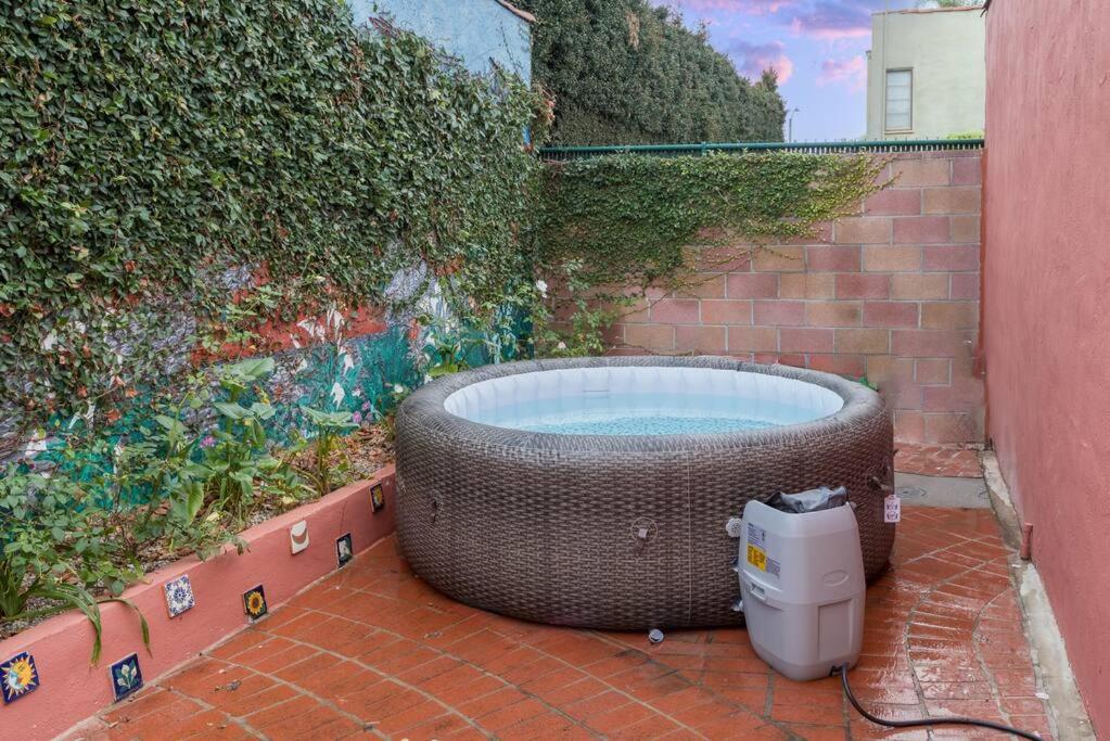 una grande vasca da bagno seduta accanto a un muro di Experience Luxury in a Spanish-Moroccan Escape a Los Angeles