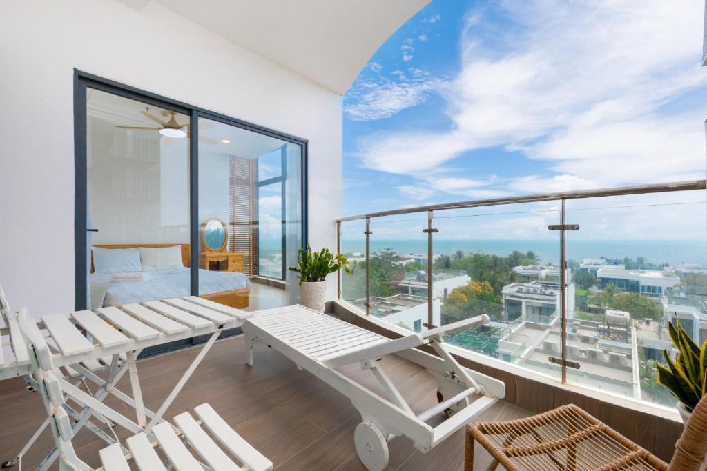 um quarto com uma varanda com uma cama e um baloiço em ARIA- VŨNG TÀU - Căn hộ, villa nghỉ dưỡng cao cấp sát bãi biển riêng miễn phí em Vung Tau