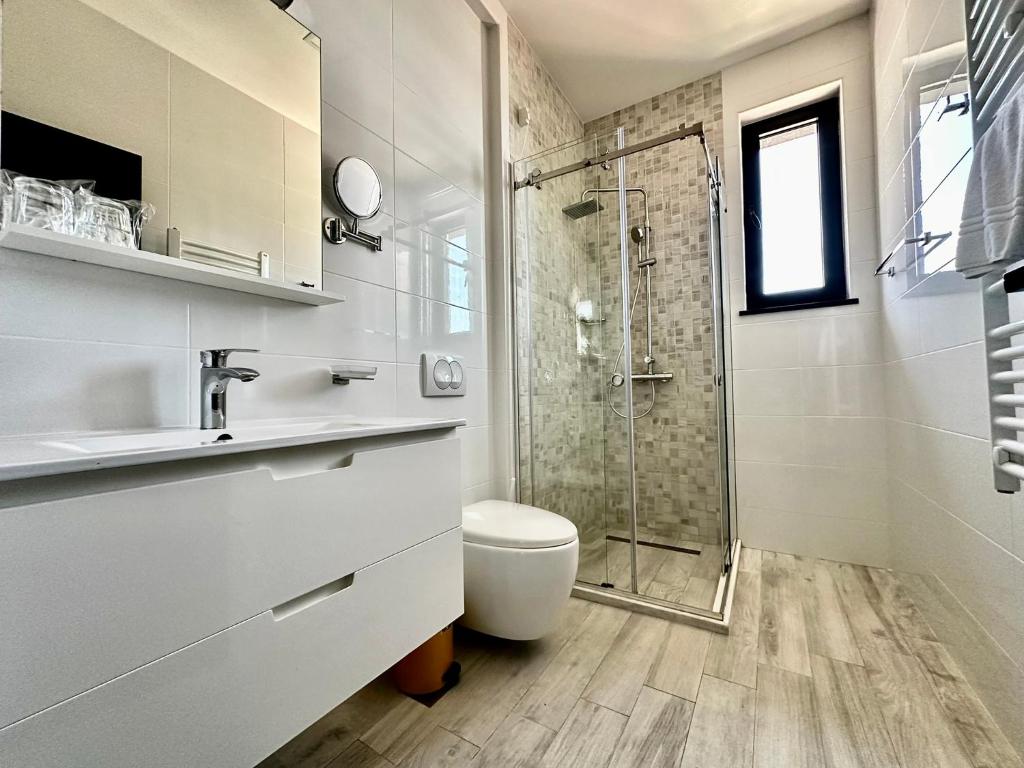 a bathroom with a shower and a toilet and a sink at Art-Hotel Del Medio in Sutomore