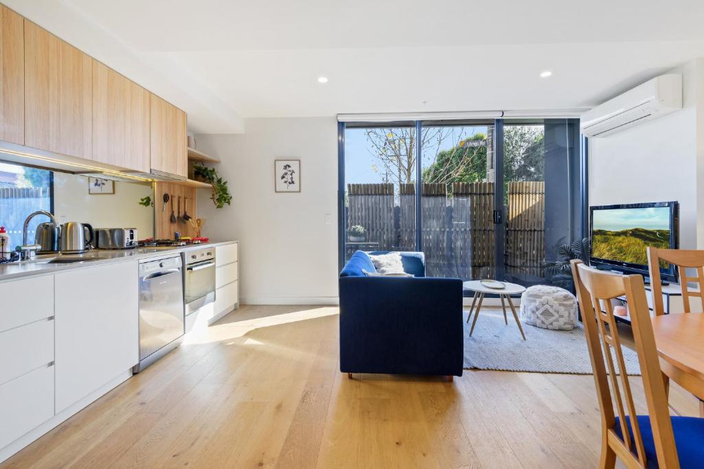 a kitchen and dining room with a table and chairs at Cosy 1-Bed with Private Balcony By Showgrounds in Melbourne