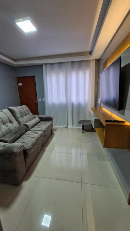 sala de estar con sofá y TV de pantalla plana en DECORADO 23-E 2 qts com ar-condicionado, en Rio Verde