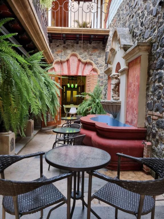 a patio with tables and chairs in a building at Central Hostel Boutique in Antigua Guatemala