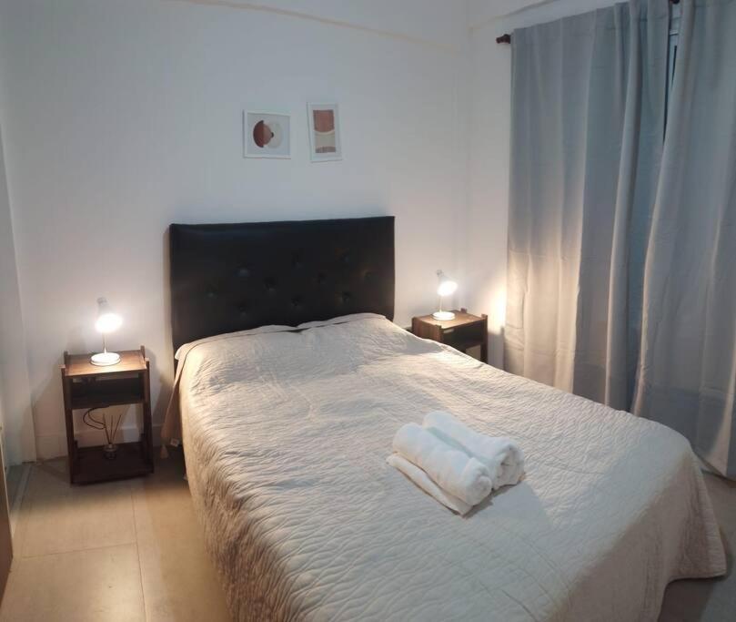 ein Schlafzimmer mit einem Bett mit zwei Handtüchern darauf in der Unterkunft Elegante residencia! in Ezeiza