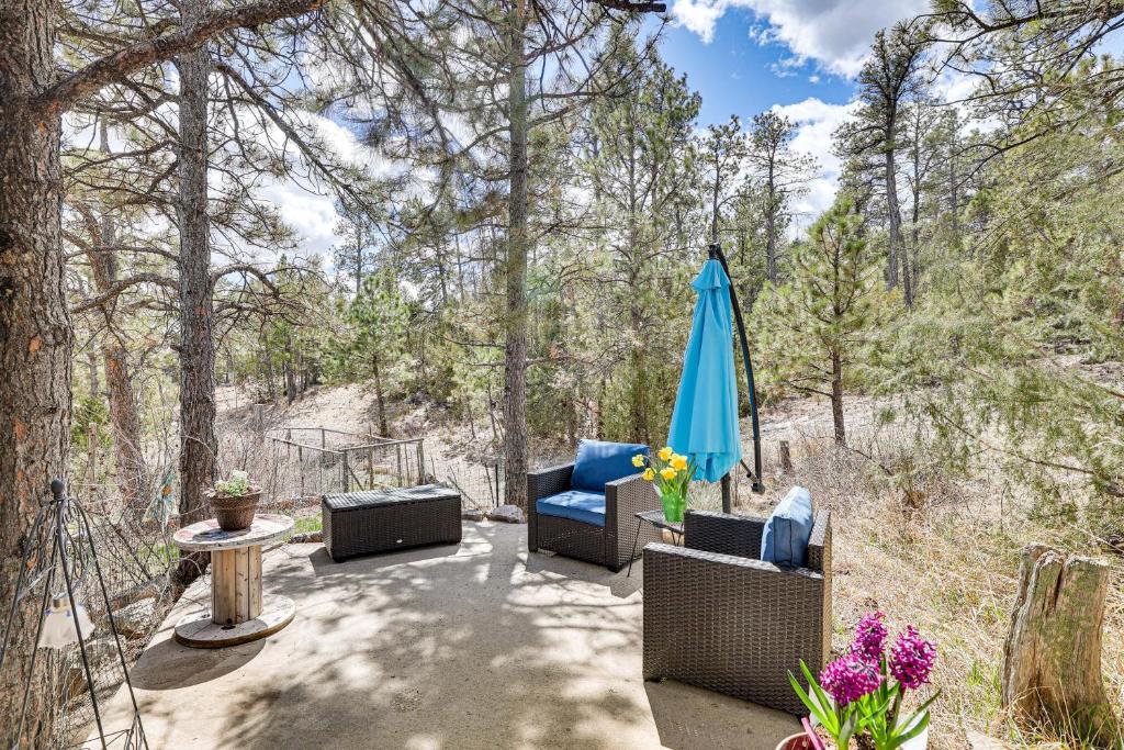 a patio with chairs and an umbrella and a table at Scenic and Serene Rapid City Getaway on 1 half Acres! in Rapid City
