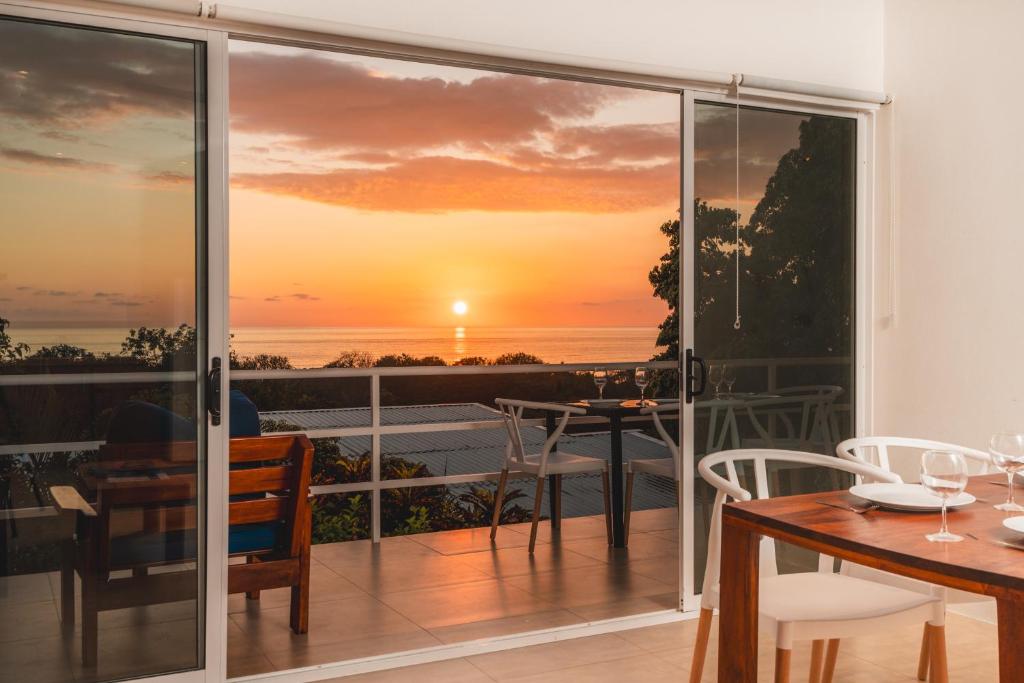 a balcony with a view of a sunset at Buena Vista Ocean View Apartments Santa Teresa in Santa Teresa Beach