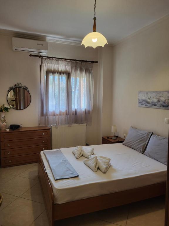 1 dormitorio con 1 cama con sábanas blancas y ventana en Apartments Irene in Sykia, en Sikia