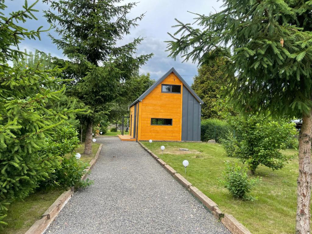 una pequeña casa en un camino de grava con árboles en Dom na Pojezierzu Łęczyńsko - Włodawskim, en Ludwin