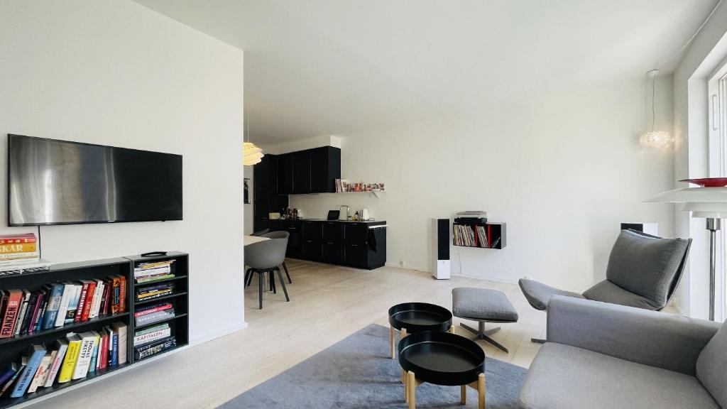 sala de estar con sofá y TV en la pared en ApartmentInCopenhagen Apartment 1608, en Copenhague