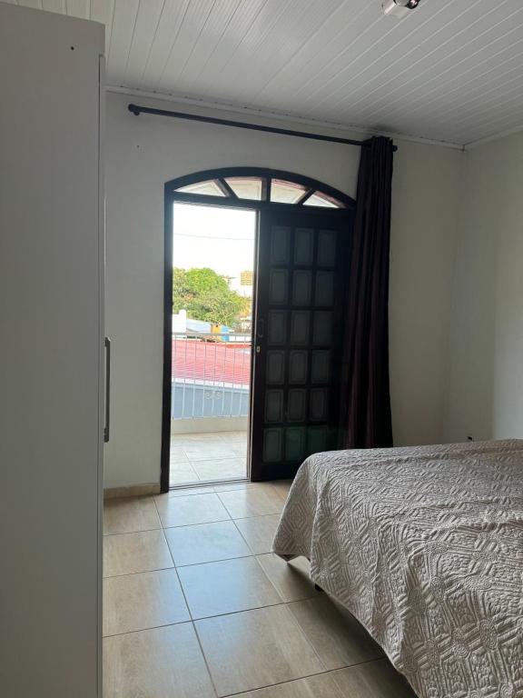 - une chambre avec un lit et une porte ouverte dans l'établissement Cantinho do Aconchego, à São Lourenço