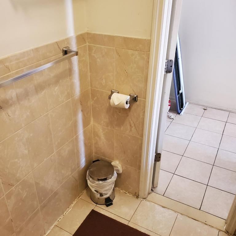 ein Bad mit einer Dusche und einem WC-Papierspender in der Unterkunft New Studio apartments Available Now!! in Port Morris