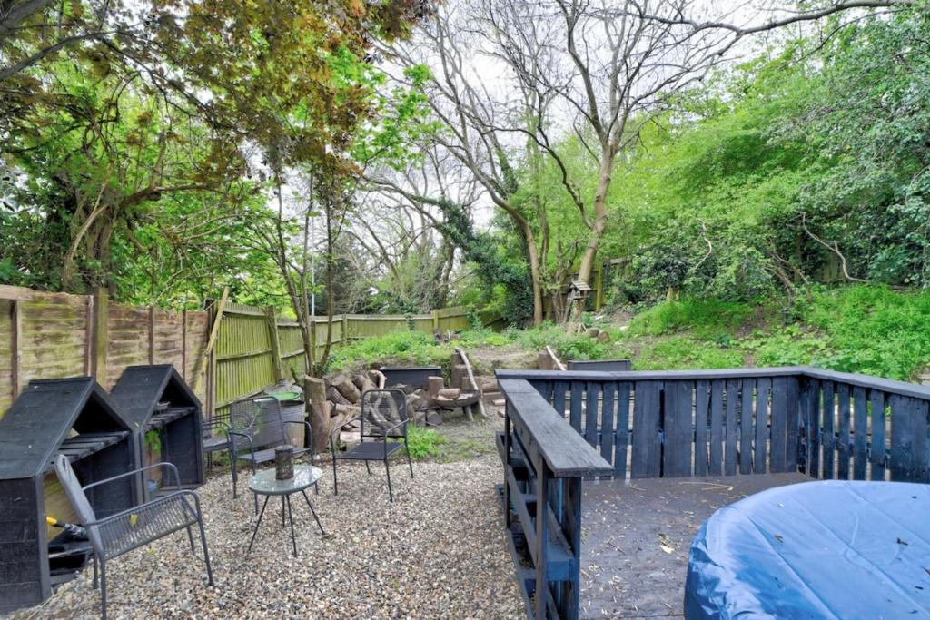 a backyard with a table and chairs and a fence at Cozy Guest Lodge with a large secluded garden in Stifford