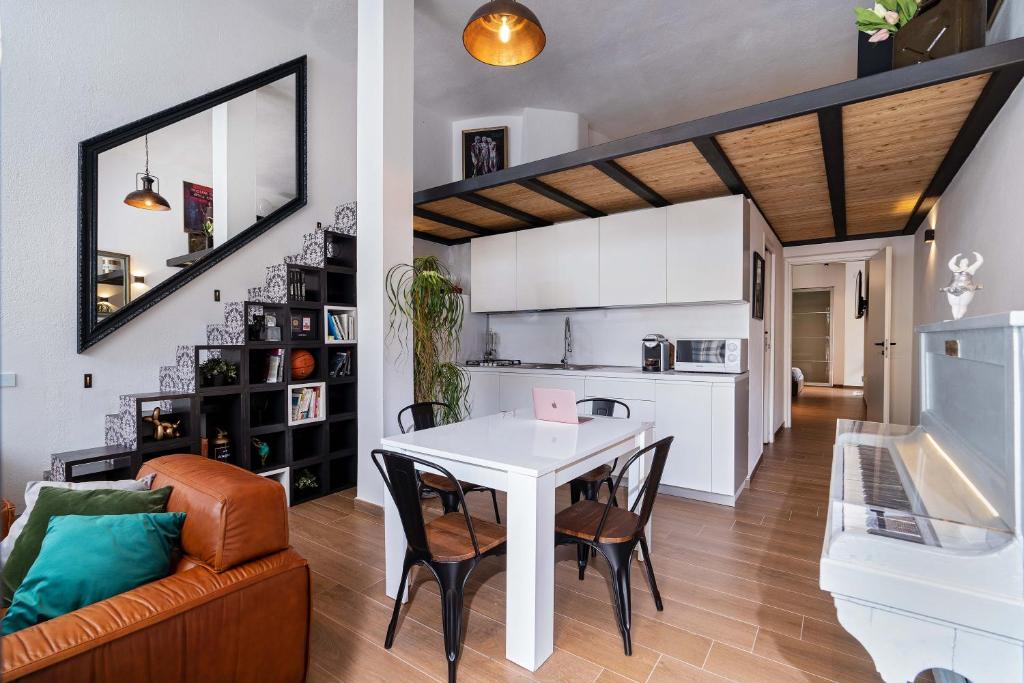 een keuken en een woonkamer met een witte tafel en stoelen bij Superbo Loft radical chic in Quartu SantʼElena