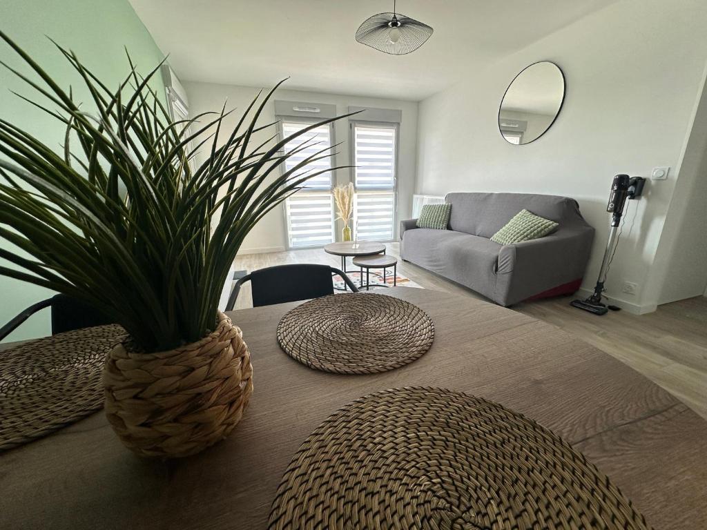 - un salon avec une table et une plante en pot dans l'établissement L'émeraude, à Cancale