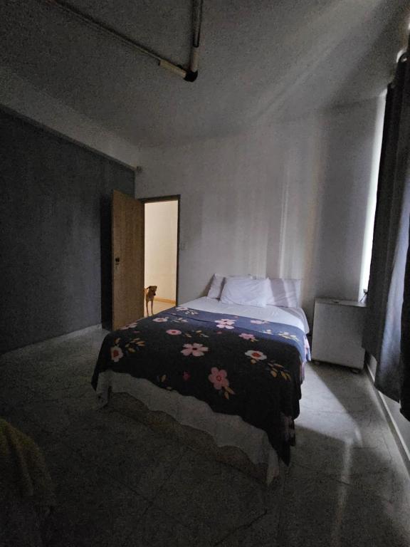 a bedroom with a bed with a black blanket with flowers at Nomads Hostel Multicultural & Coworking in Salvador