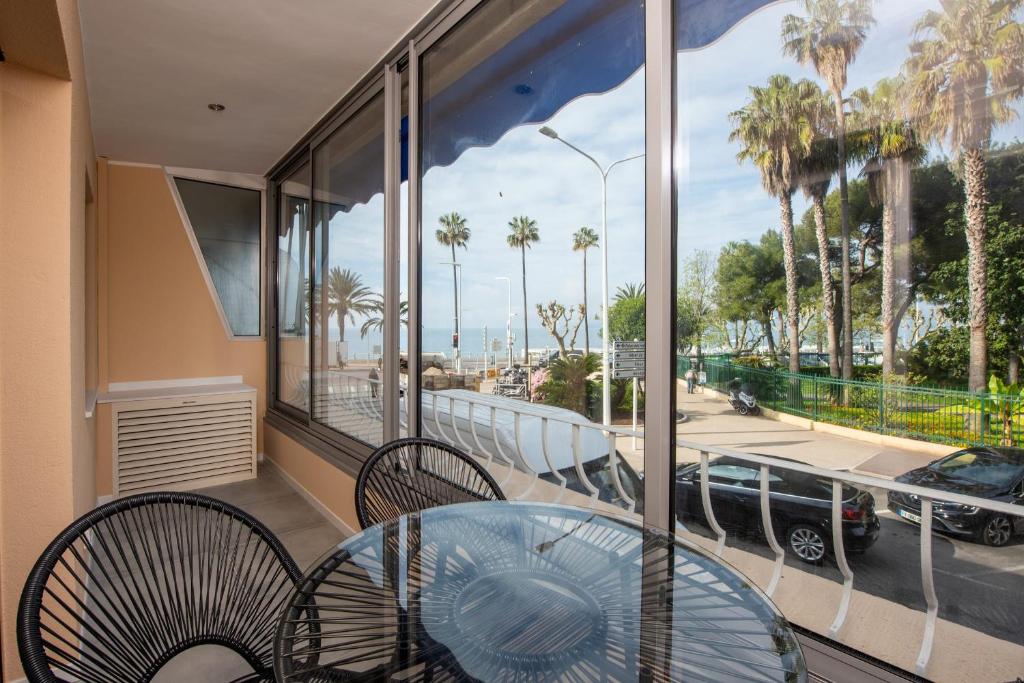 d'un balcon avec vue doté d'une table et de chaises en verre. dans l'établissement Appartement Dollia - Welkeys, à Cannes