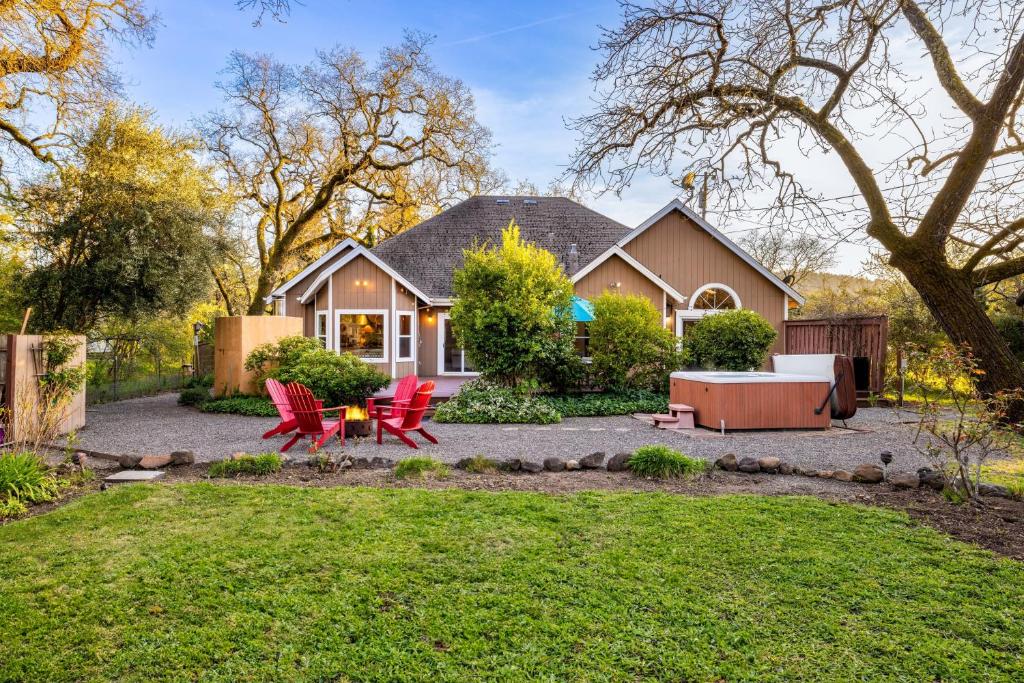una casa con sillas rojas y una mesa en el patio en Valley of the Moon by AvantStay Tranquil Escape Large Yard w Hot Tub Fire Pit, en Kenwood