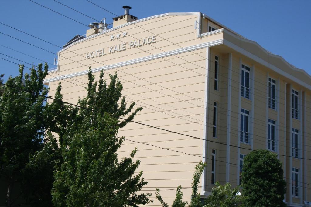 a building with a sign on the side of it at Kale Palace Hotel in Gokceada Town