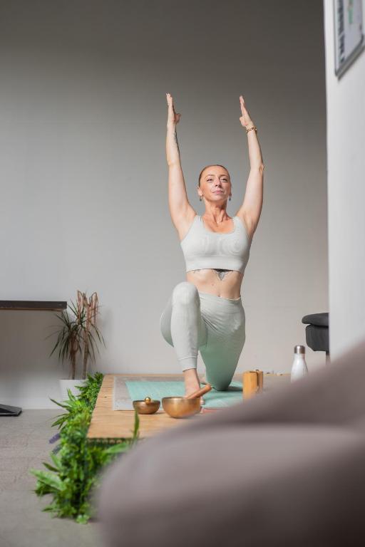 una mujer haciendo una pose de yoga en una habitación en Hôtel d'Angleterre, Salon-de-Provence, en Salon-de-Provence