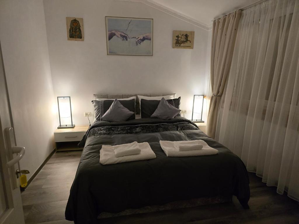 a bedroom with a bed with two towels on it at ELDI House in Făgăraş