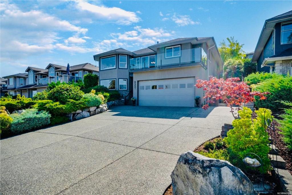 une grande maison avec garage dans une cour dans l'établissement Marine Melody, à Nanaimo