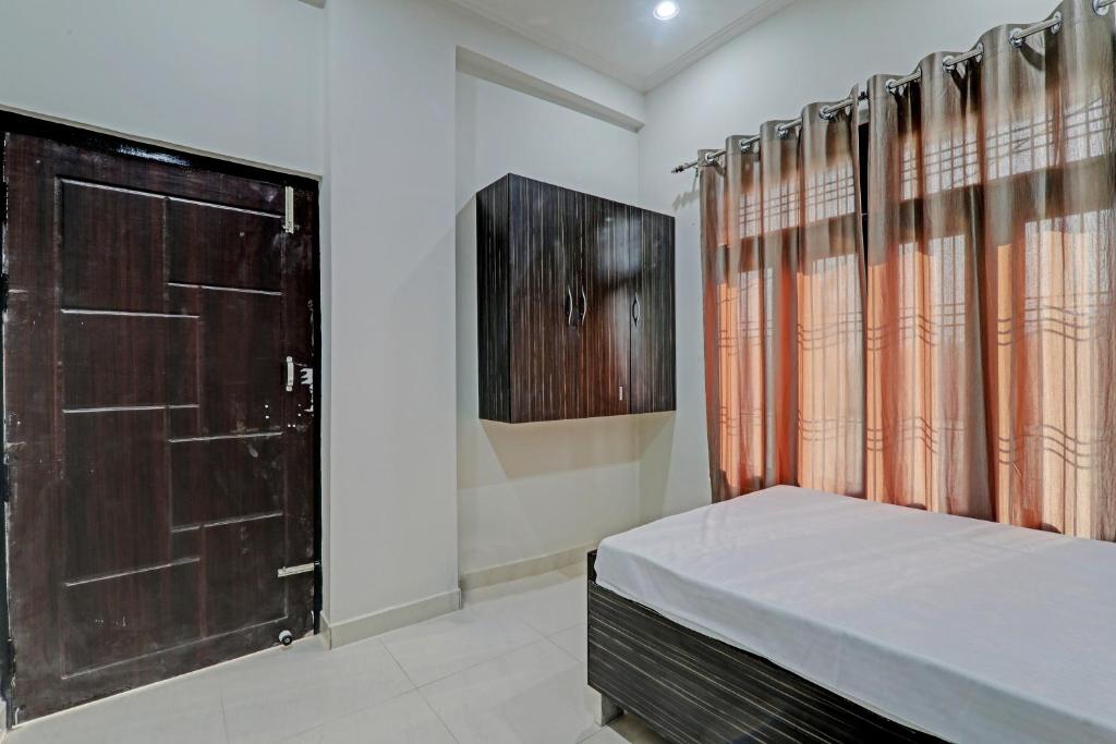 een slaapkamer met een bed en een houten deur bij SSK Hotel in Lucknow