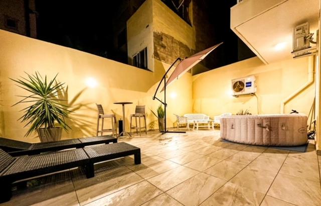 a room with a bench and a table and chairs at Sliema Jacuzzi Flat in Sliema